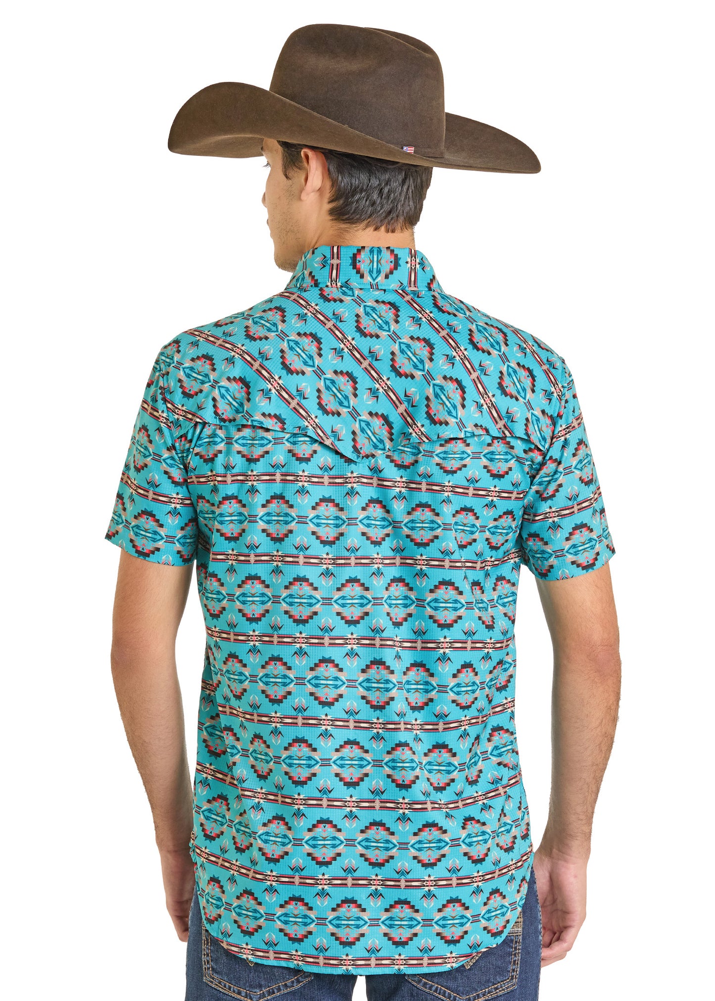 A man in a brown cowboy hat wears the Rock & Roll Denim TEK Western Daring Aztec Short Sleeve Shirt with UPF 50, seen from behind to show the back of the shirt and his blue jeans.
