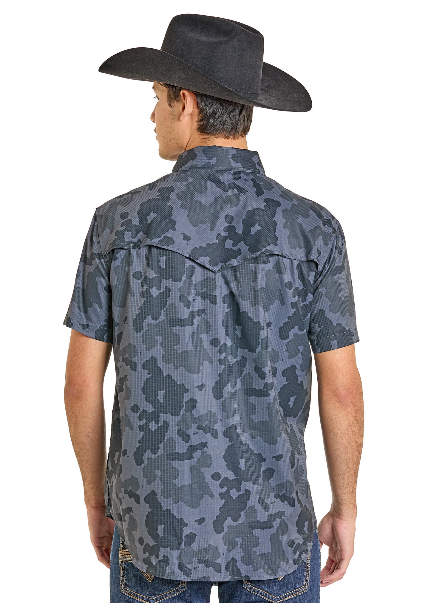 A man is seen from the back wearing a black cowboy hat, blue jeans, and a Rock & Roll Denim TEK Western Black Camo Short Sleeve Shirt with UPF 50.