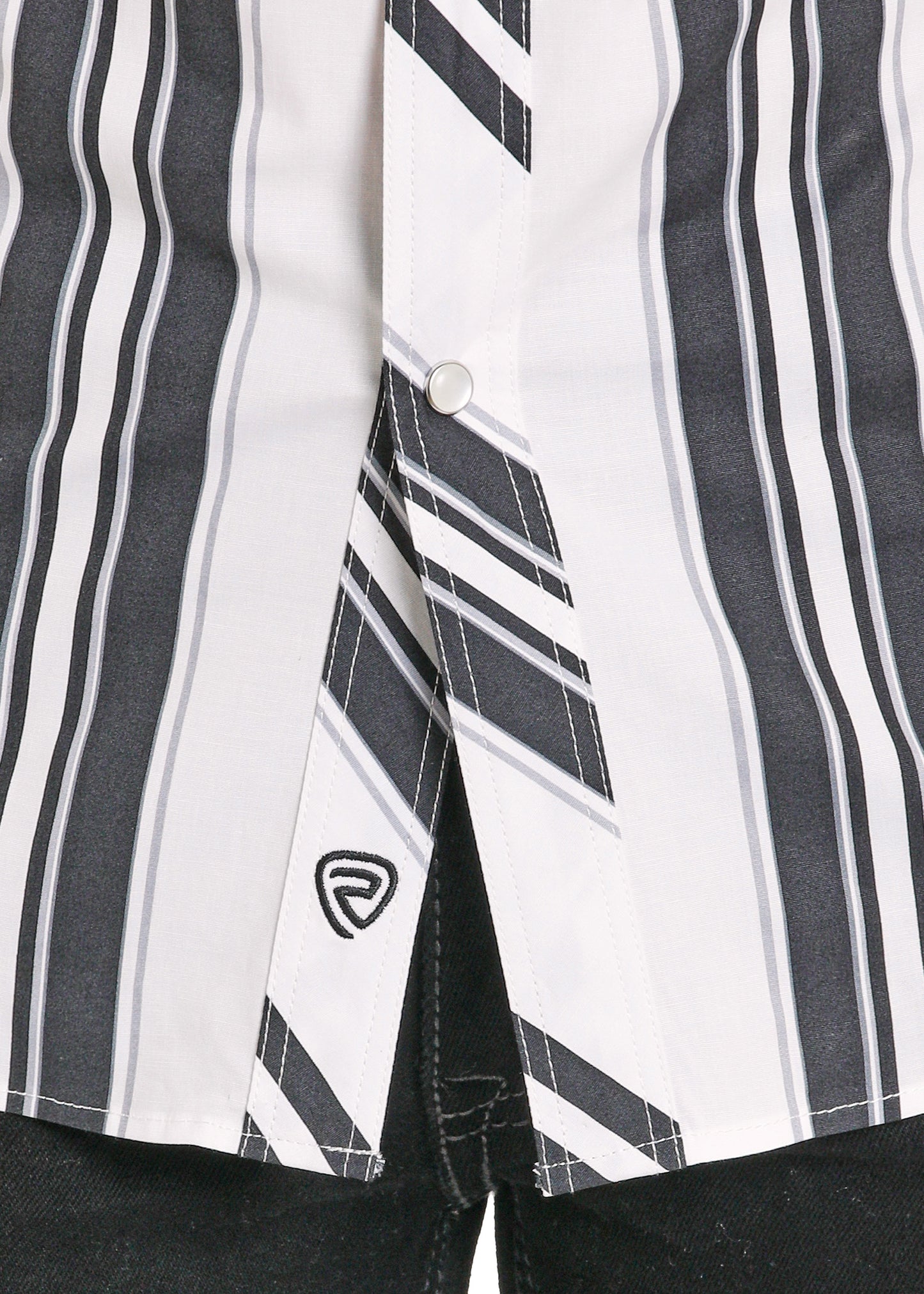 Close-up of a black and white striped shirt with a brand logo on a dark background