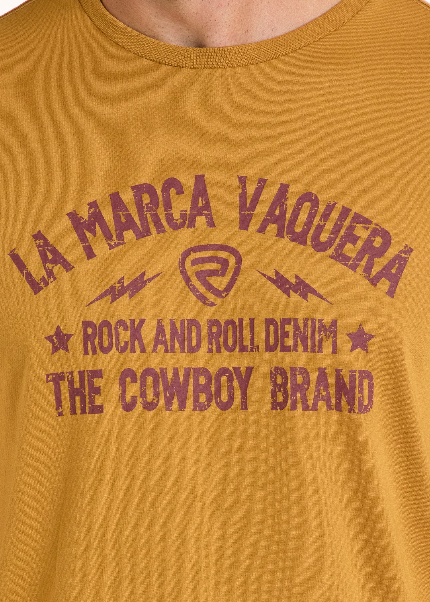 The La Marca Vaquero Graphic Tee by Rock & Roll Denim stands out with distressed purple text and bold star and lightning bolt graphics on a comfortable mustard yellow shirt.