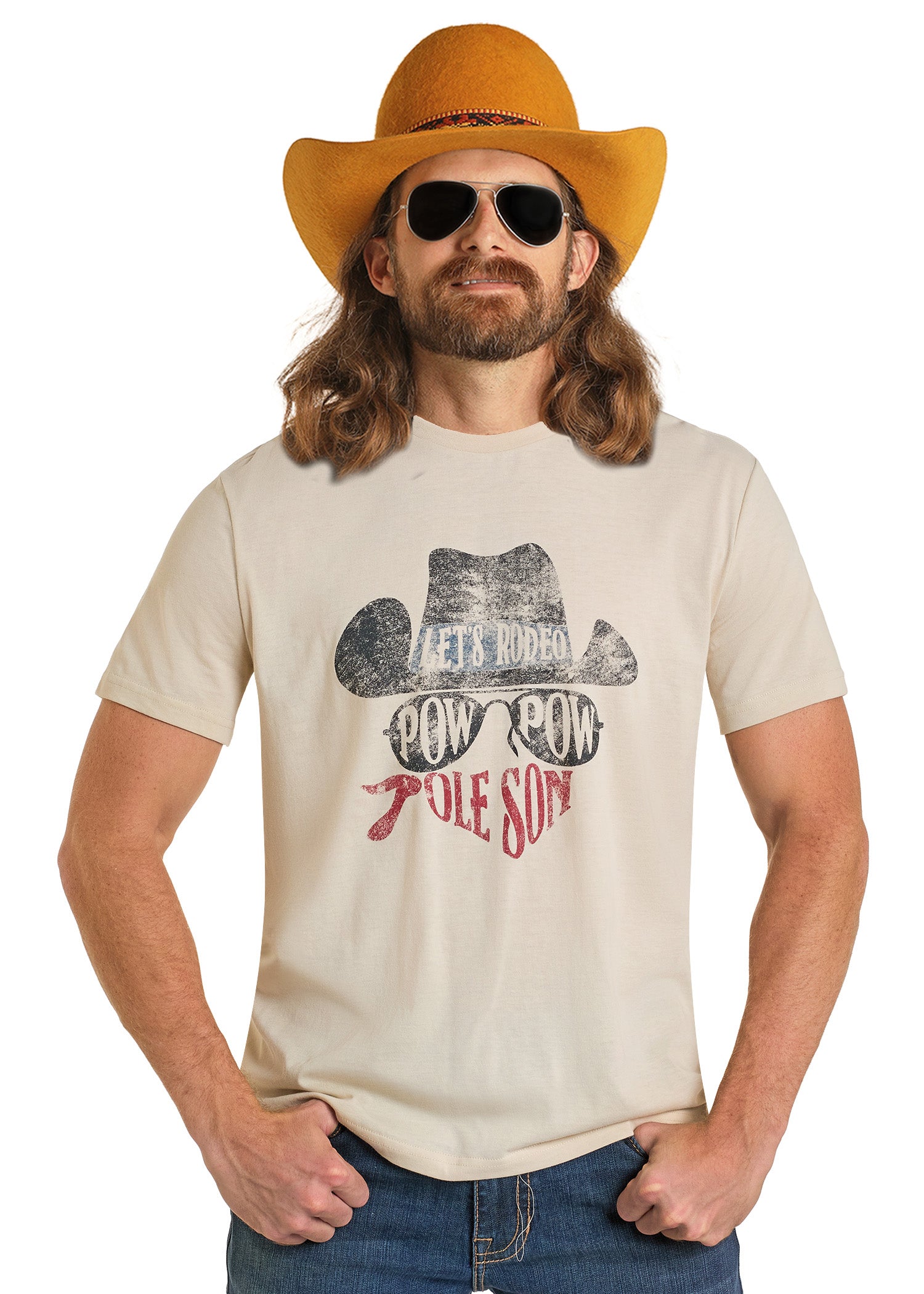 A man with long hair and a beard wears a cowboy hat, sunglasses, and the Rock & Roll Denim Dale Brisby Pow Pow Graphic Tee. Channeling Dale Brisby vibes, he stands with his hands on his hips, smiling slightly.