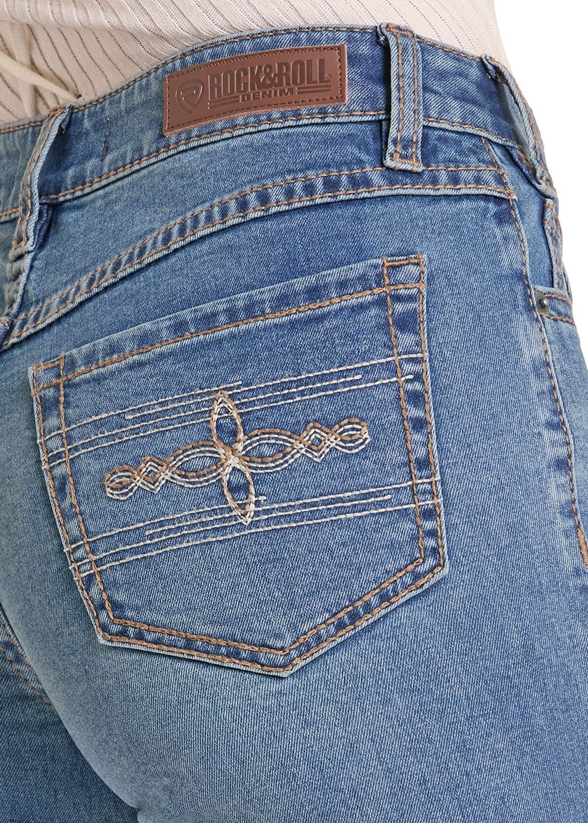 Close-up of the back pocket of light-wash blue denim jeans, showing decorative metallic embroidery on the pocket and a brown Rock & Roll brand patch at the waistband.