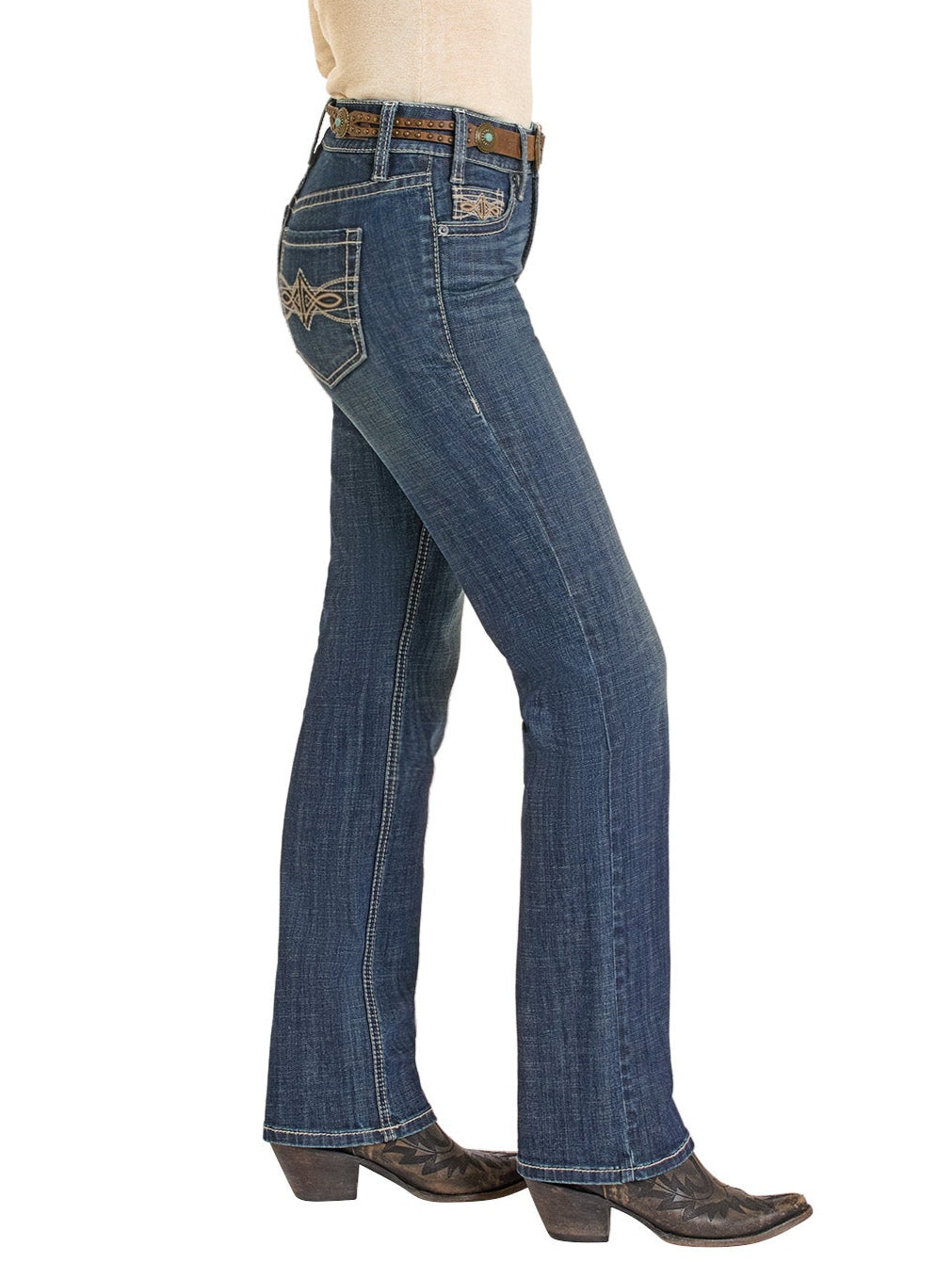 A person wearing Rock & Roll Denim Mid Rise Leather Embroidered Pocket Modest Bootcut Jeans, styled with a brown belt and dark cowboy boots, stands in side profile against a white background.