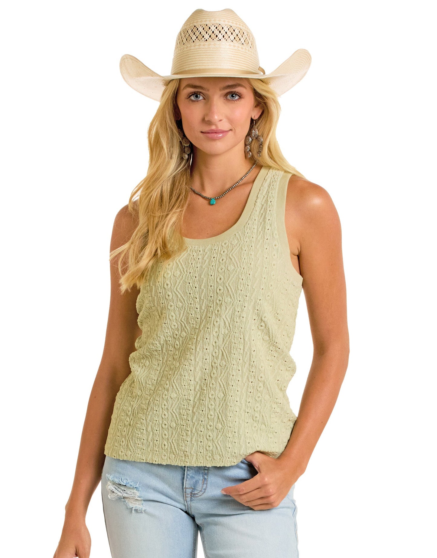 A woman in a Rock & Roll Denim Raised Knit Tank Top, distressed light blue jeans, and a straw cowboy hat stands with one hand in her pocket. She wears layered necklaces and earrings for a relaxed and casual look.