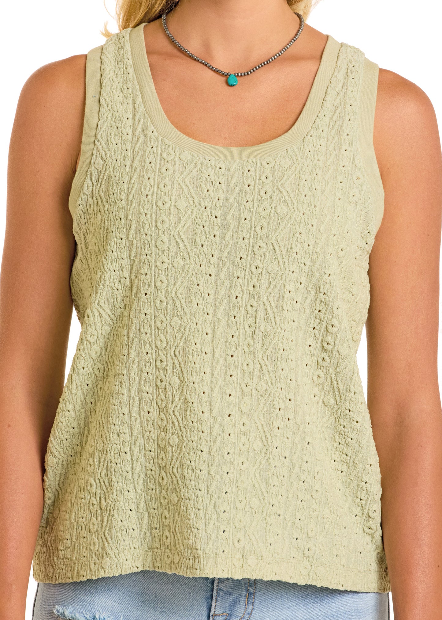 A woman wears a light green, sleeveless Rock & Roll Denim Raised Knit Tank Top with lace details and a scoop neckline, styled with a silver turquoise pendant necklace and distressed light blue jeans against a white background for a casual look.