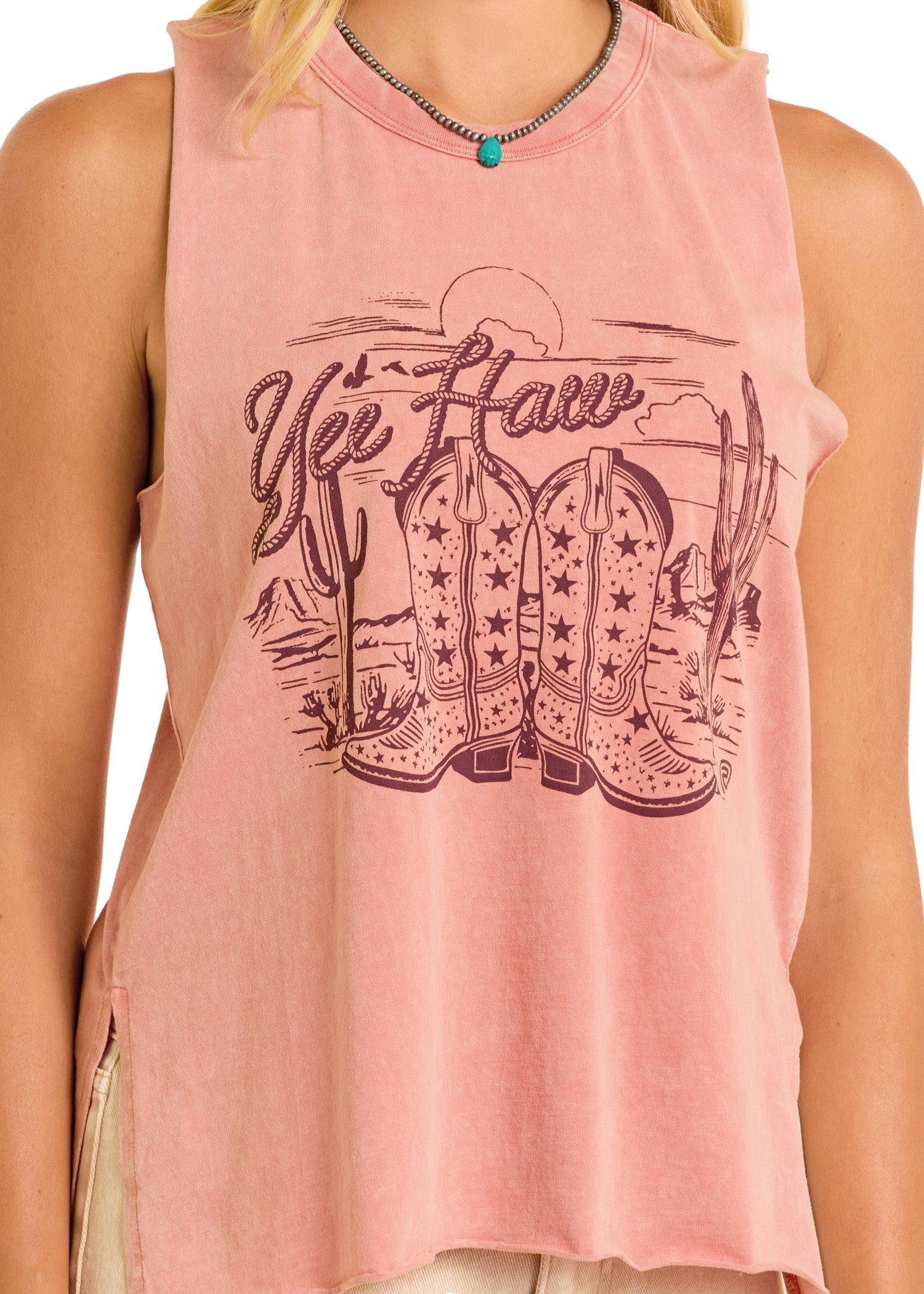 Someone wears the Rock & Roll Denim Yee Haw Graphic Tank, made of 100% cotton, featuring cowboy boots, cacti, a desert scene, and "Yee Haw" text above the Western-themed illustration.
