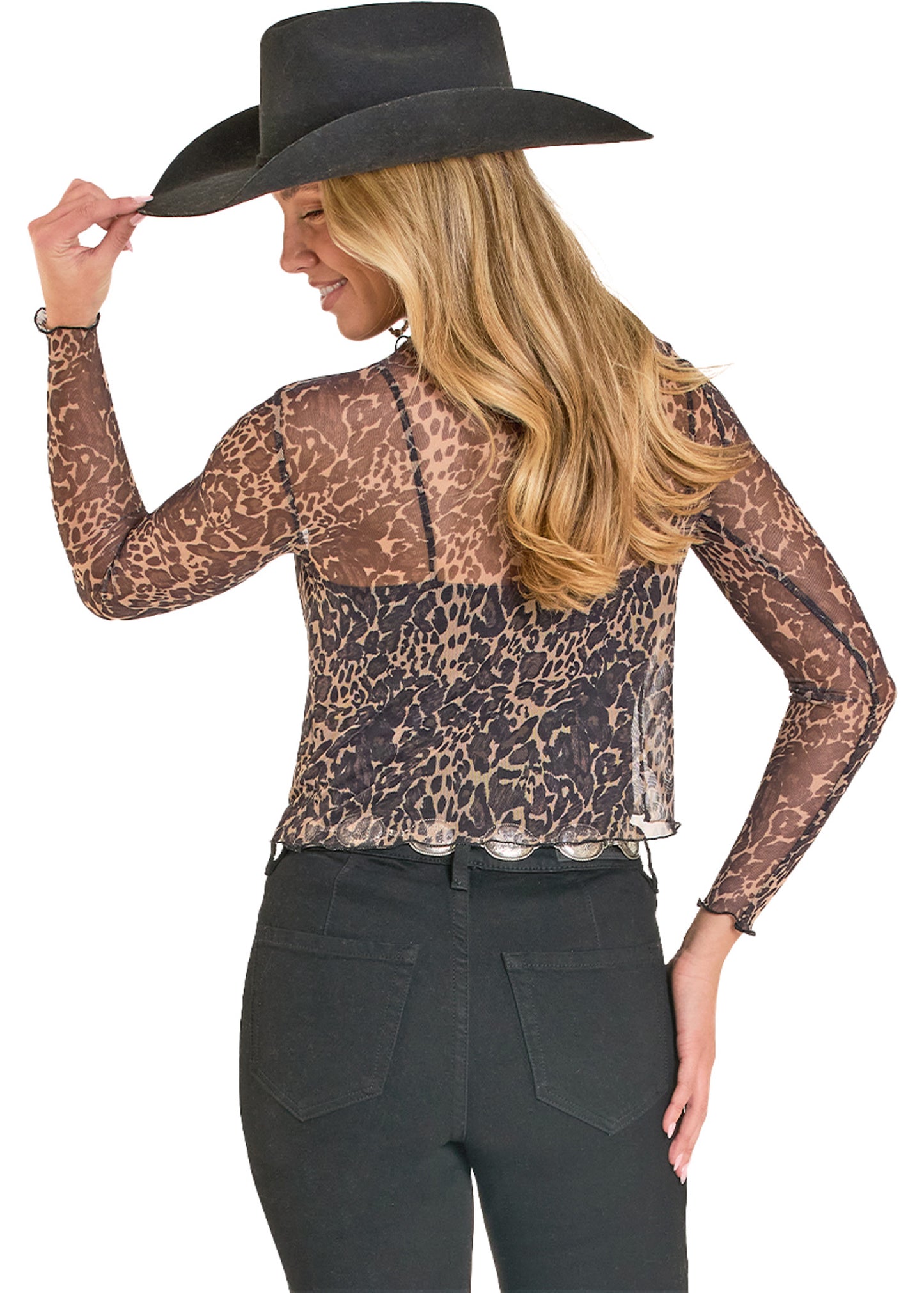 Woman wearing a leopard print top and black cowboy hat on a white background