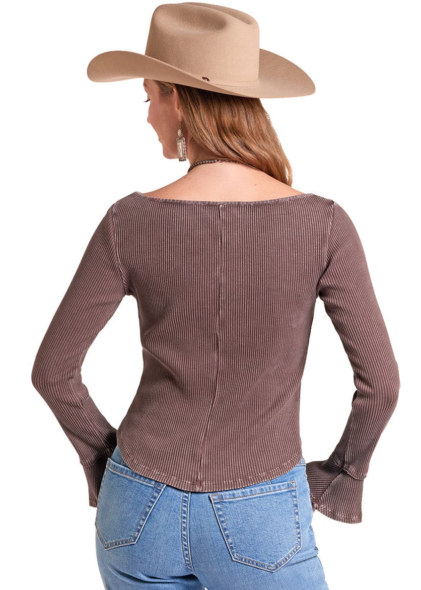 A woman shown from the back wearing a brown long-sleeve western-style top, light blue jeans.