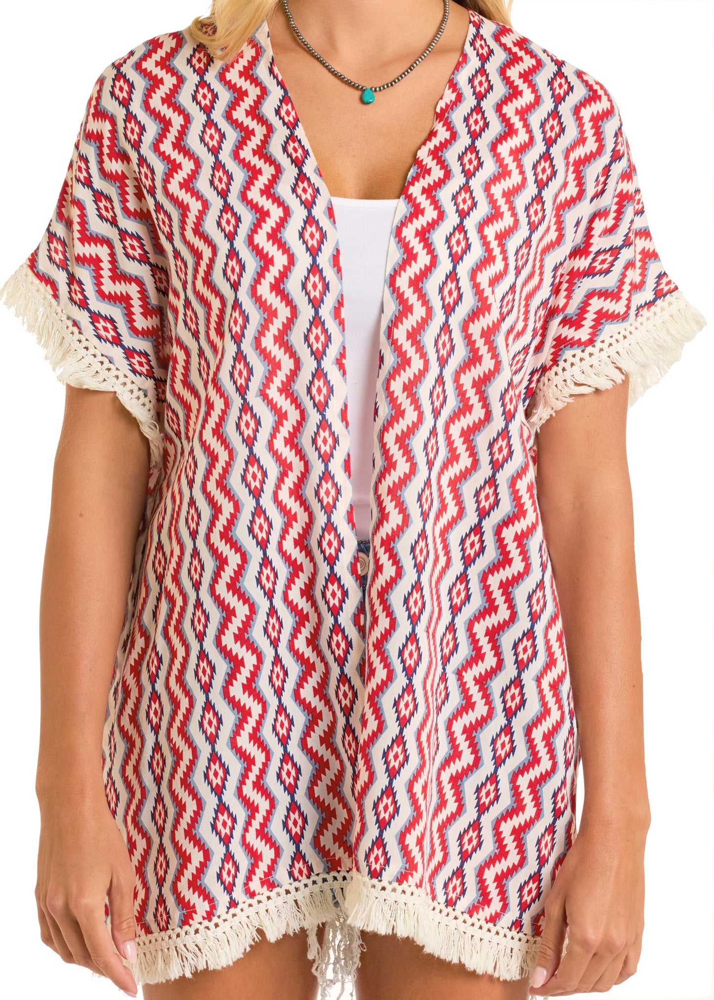 A person wears the Rock & Roll Denim American Aztec Fringe Kimono, a boho-chic layering piece with red, white, and blue zigzag patterns, cream fringe trim, short sleeves, open front, loose fit, and a white top underneath.