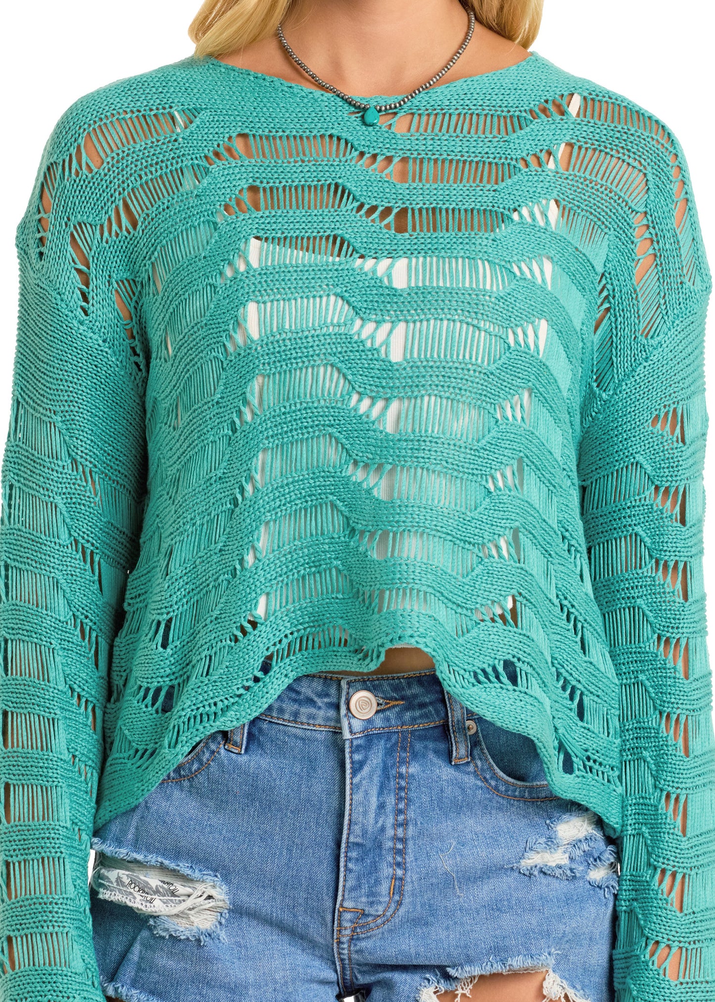 A person wears a turquoise Rock & Roll Denim Open Knit Pullover Sweater - L over a white top and distressed denim shorts. The loose, wavy, see-through sweater has long sleeves with only the midsection shown.