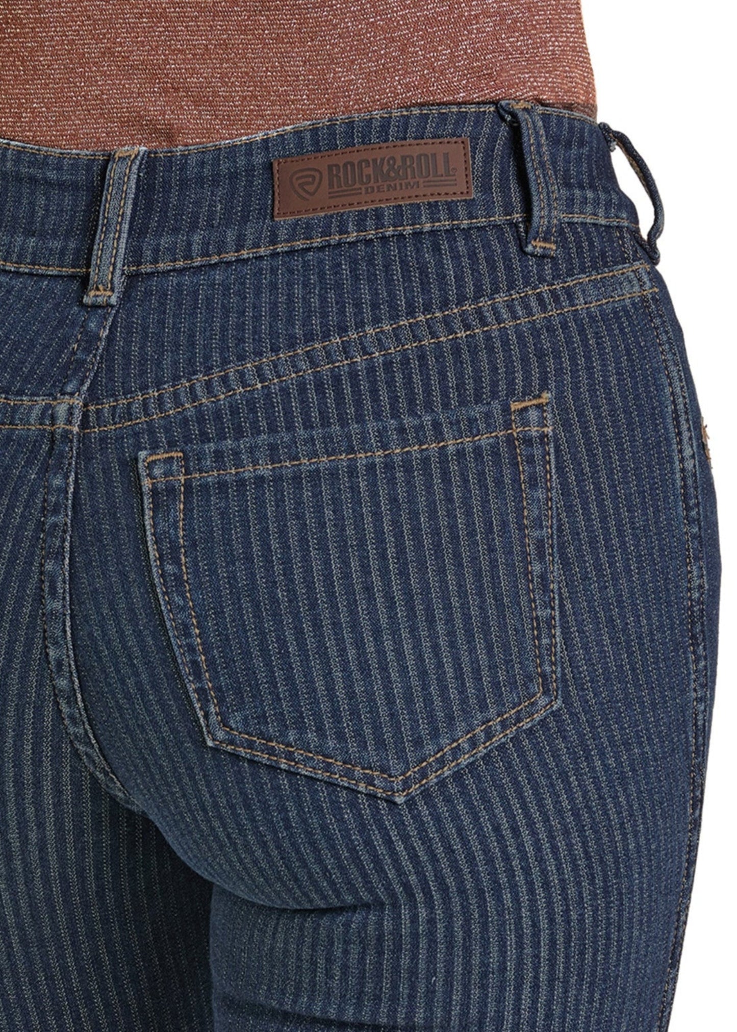 Close-up of a person wearing the West Desperado High Rise Striped Jacquard Bootcut Jeans by Rock & Roll Denim, featuring visible back pockets and a branded leather patch label.