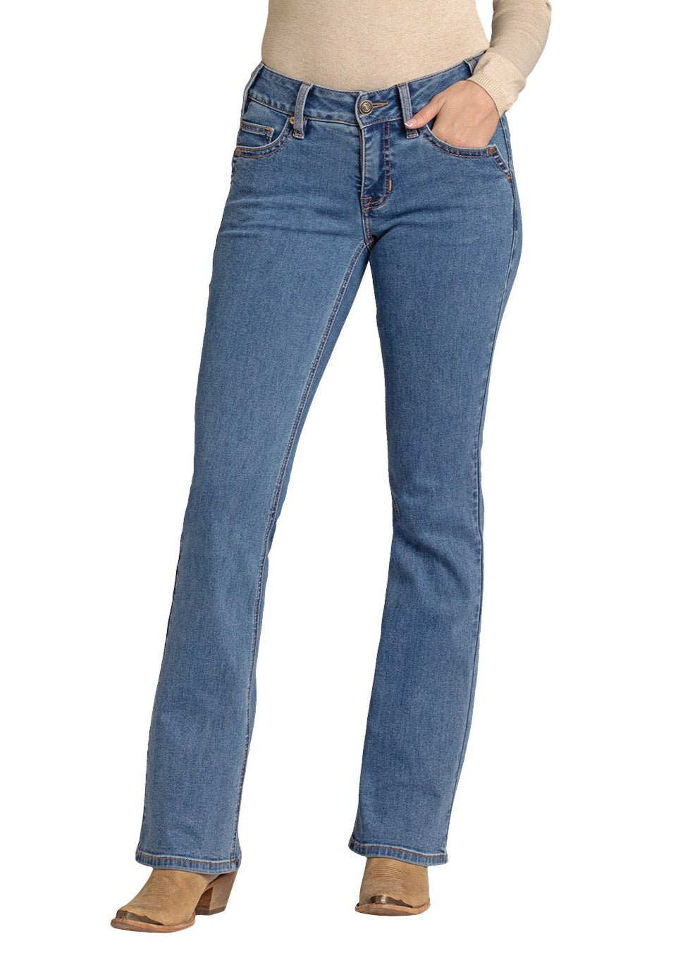 A person wears Rock & Roll Denim's Mid Rise Classic Boot Embroidered Bootcut Jean in light blue, paired with a beige long-sleeve top and tan heeled boots, one hand in their pocket, standing against a white background.