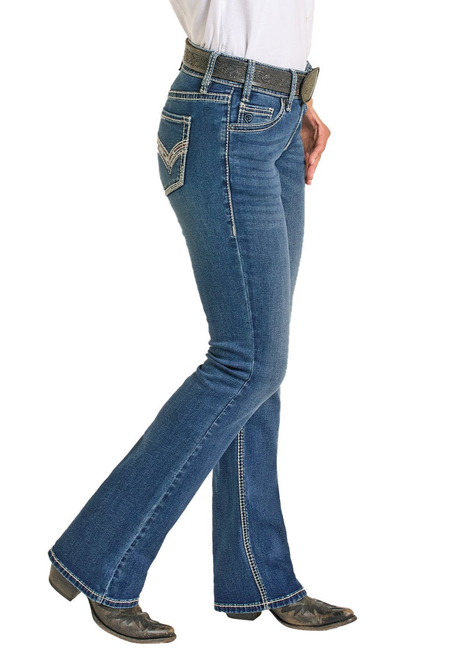 A person models Rock & Roll Denim’s Mid Rise Cowhide Stitch Bootcut Riding Jeans, paired with a black belt and black cowboy boots, shown from the side against a white background.