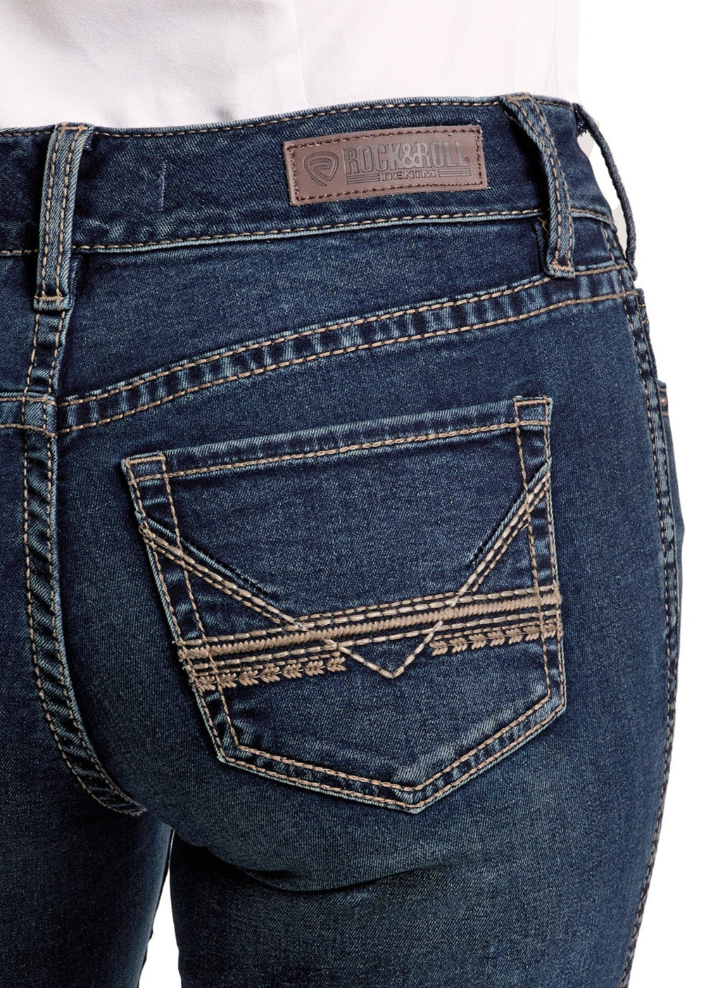 Close-up of the back pocket on Rock & Roll Denim’s Mid Rise Classic Stitch Bootcut Riding Jeans, featuring decorative stitching and a brown leather label. The jeans are modeled with a white shirt.