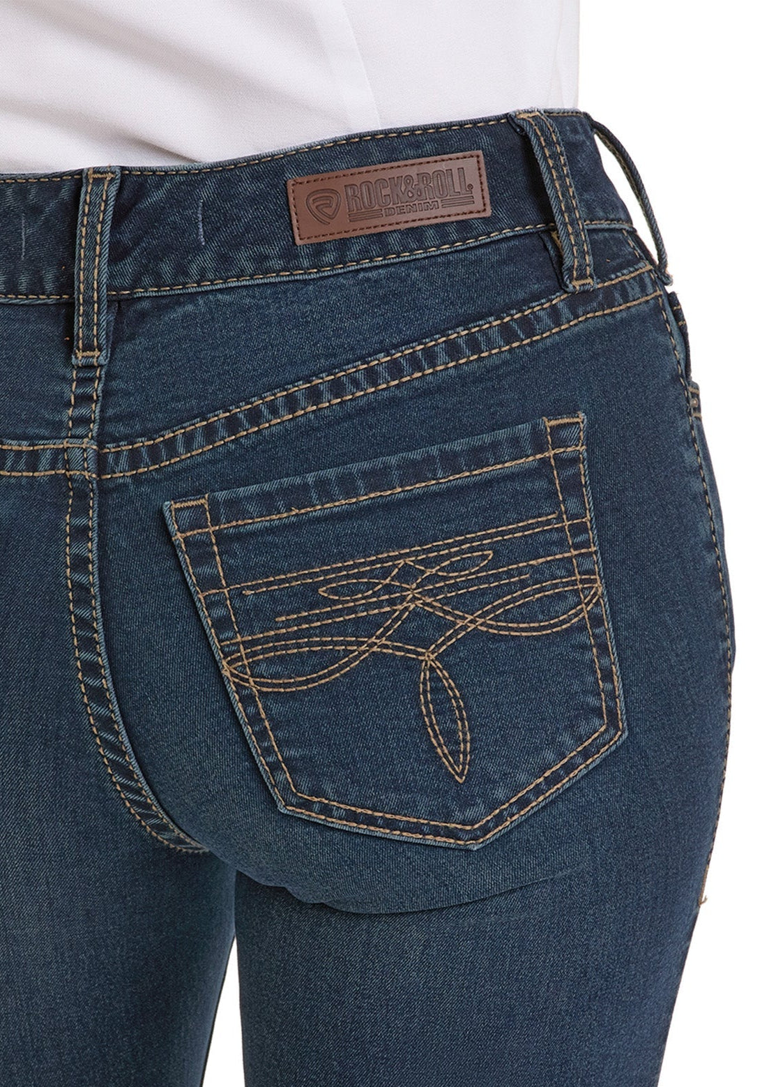 Close-up of a person wearing Rock & Roll Denim Mid Rise Boot Stitch Bootcut Riding Jeans featuring decorative back pocket stitching and a brown leather waistband patch.