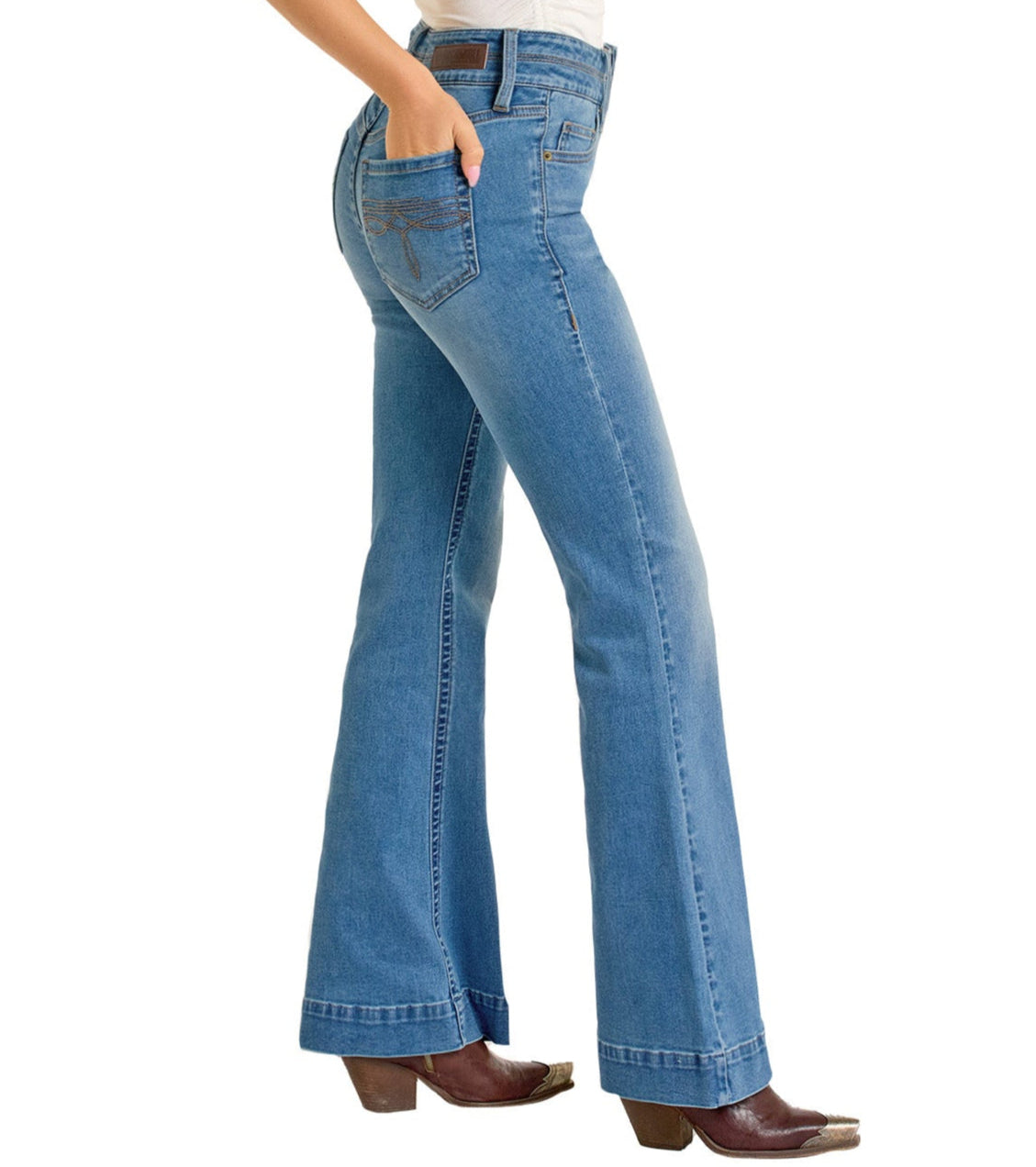 A person stands in a side view wearing Rock & Roll Denim High Rise Double Waistband Trousers in light blue with visible seams and a classic five-pocket design, paired with brown heeled boots and one hand resting on the back pocket.