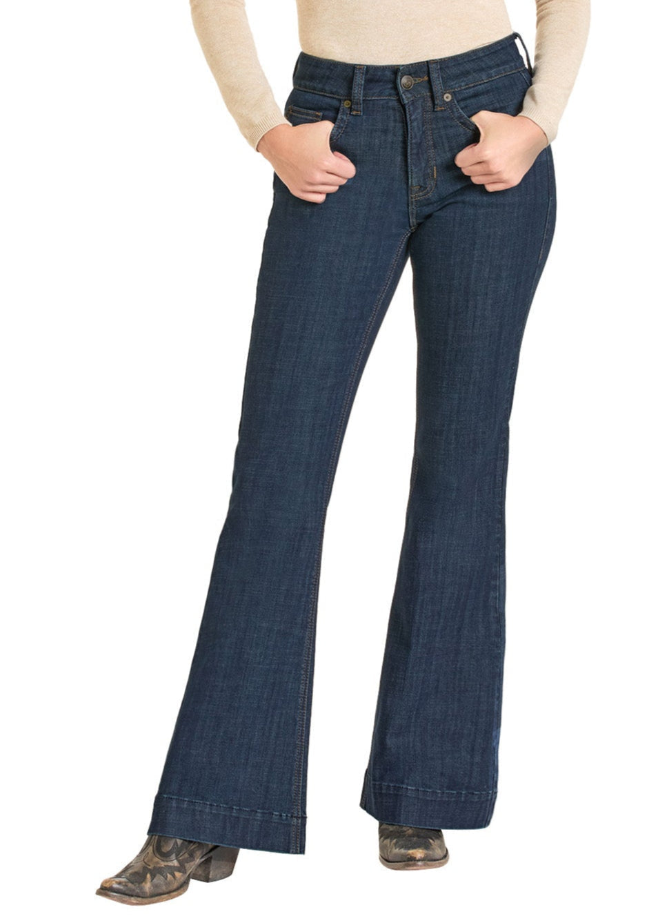 A person models Rock & Roll Denim High Rise Welt Trouser Jeans, paired with a beige long-sleeve top and patterned heeled boots, standing with hands in pockets against a white background.