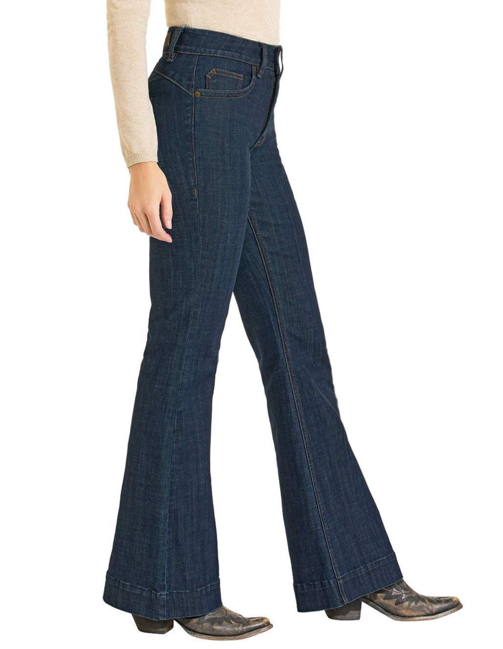A person in Rock & Roll Denim High Rise Welt Trouser Jeans, a beige long-sleeve top, and pointed black boots is shown from the side against a white background.