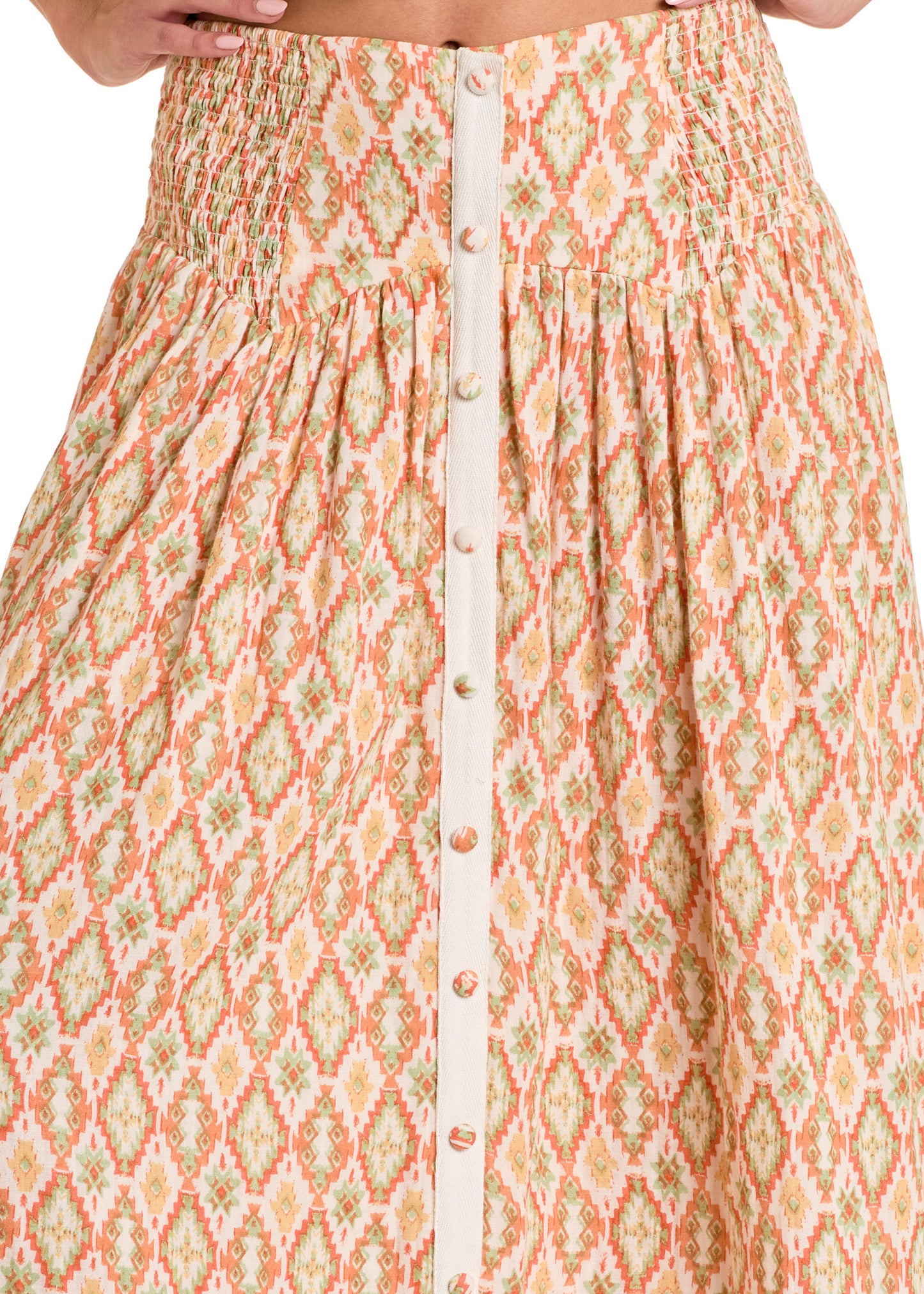 A close-up of a person wearing the Rock & Roll Denim Aztec Print Maxi Skirt, featuring a geometric pattern in orange, green, and cream with a button-down front.
