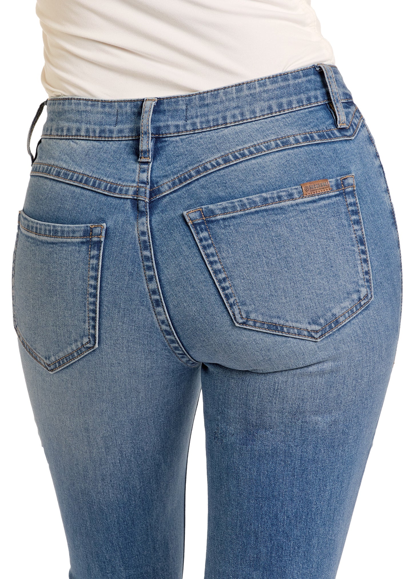 A person wearing Rock & Roll Denim's Medium Wash High Rise Bell Bottoms and a white top is shown from the waist down, highlighting the light blue denim, back pockets, and seam details of these jeans.