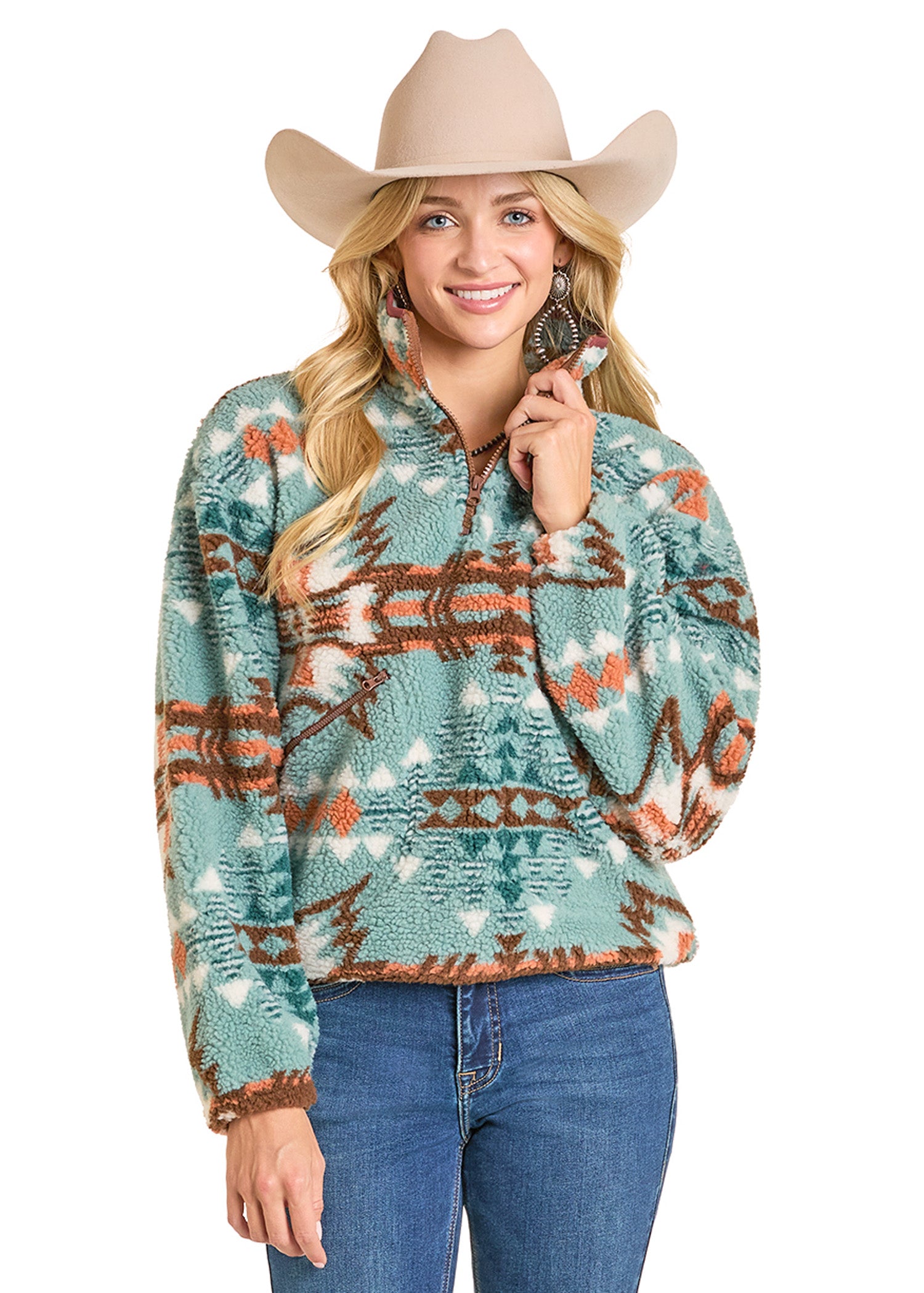 A smiling woman in a tan cowboy hat and large hoop earrings wears the Rock & Roll Denim Aztec Sherpa Pullover with blue jeans. She has long blonde hair and poses with one hand touching her collar.