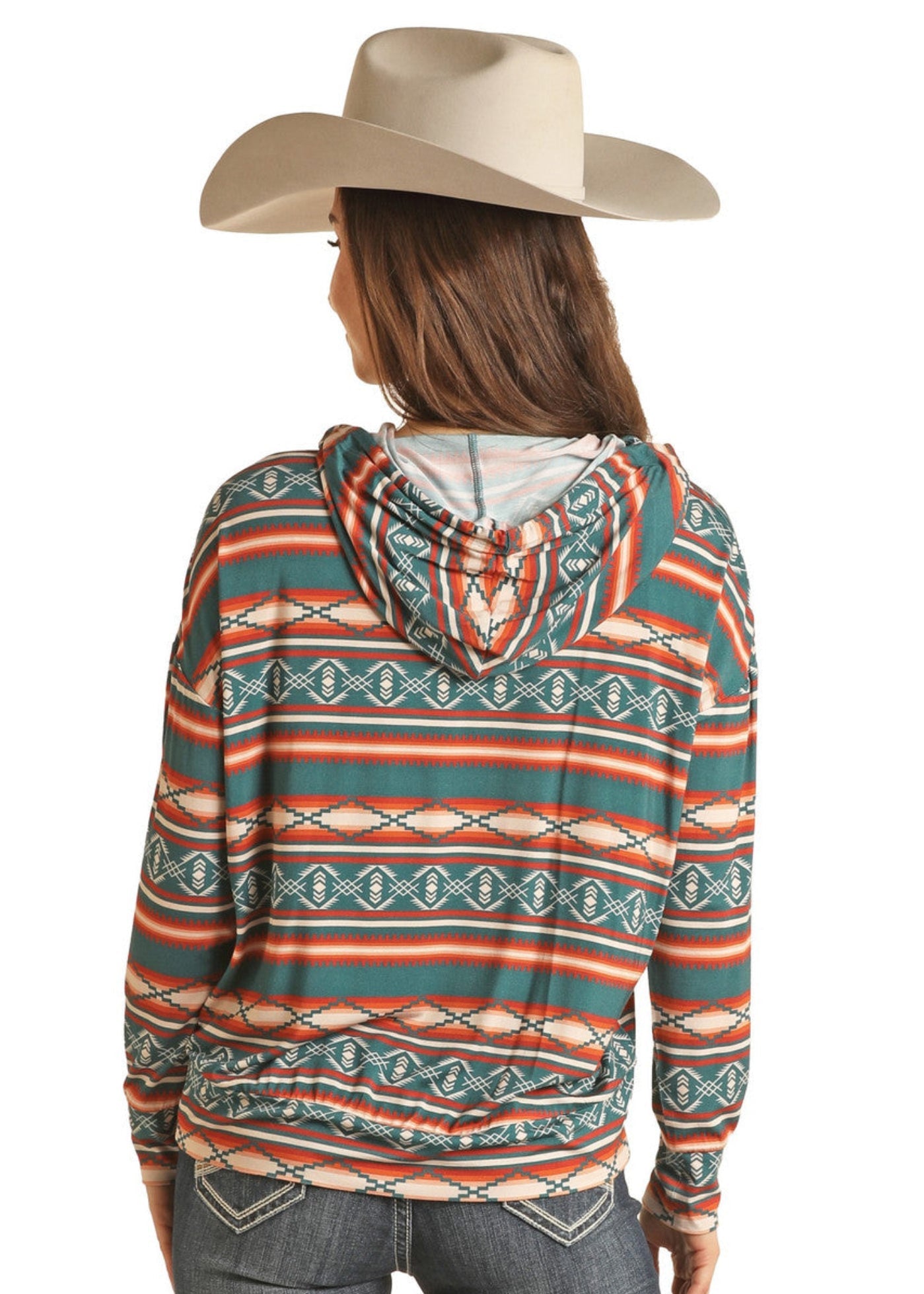 A woman, shown from behind in a beige cowboy hat and blue jeans, models the Rock & Roll Denim Striped Aztec Hoodie featuring long sleeves and teal, orange, and cream stripes against a white background.