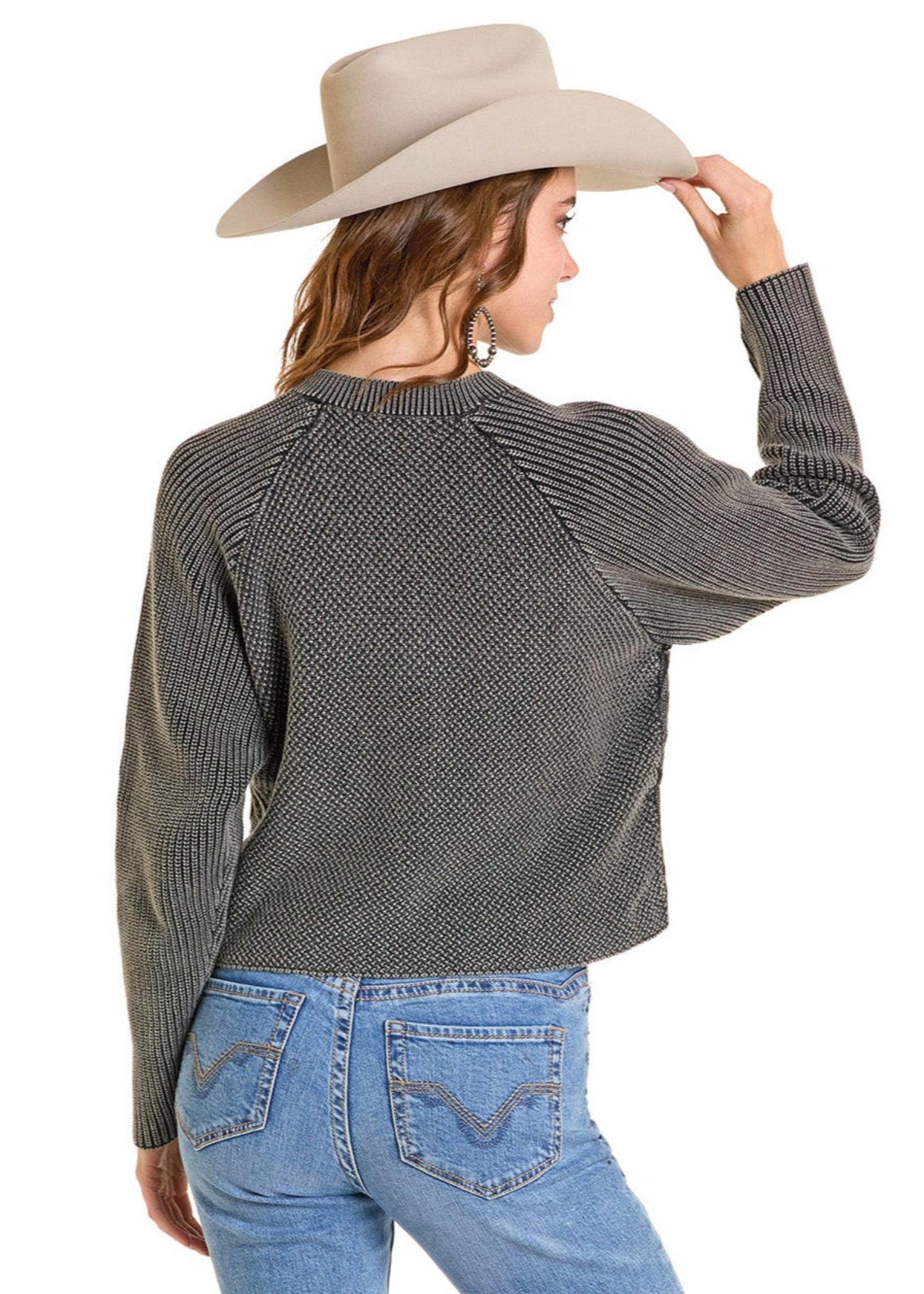Person wearing a gray sweater, blue jeans, and a beige cowboy hat on a white background