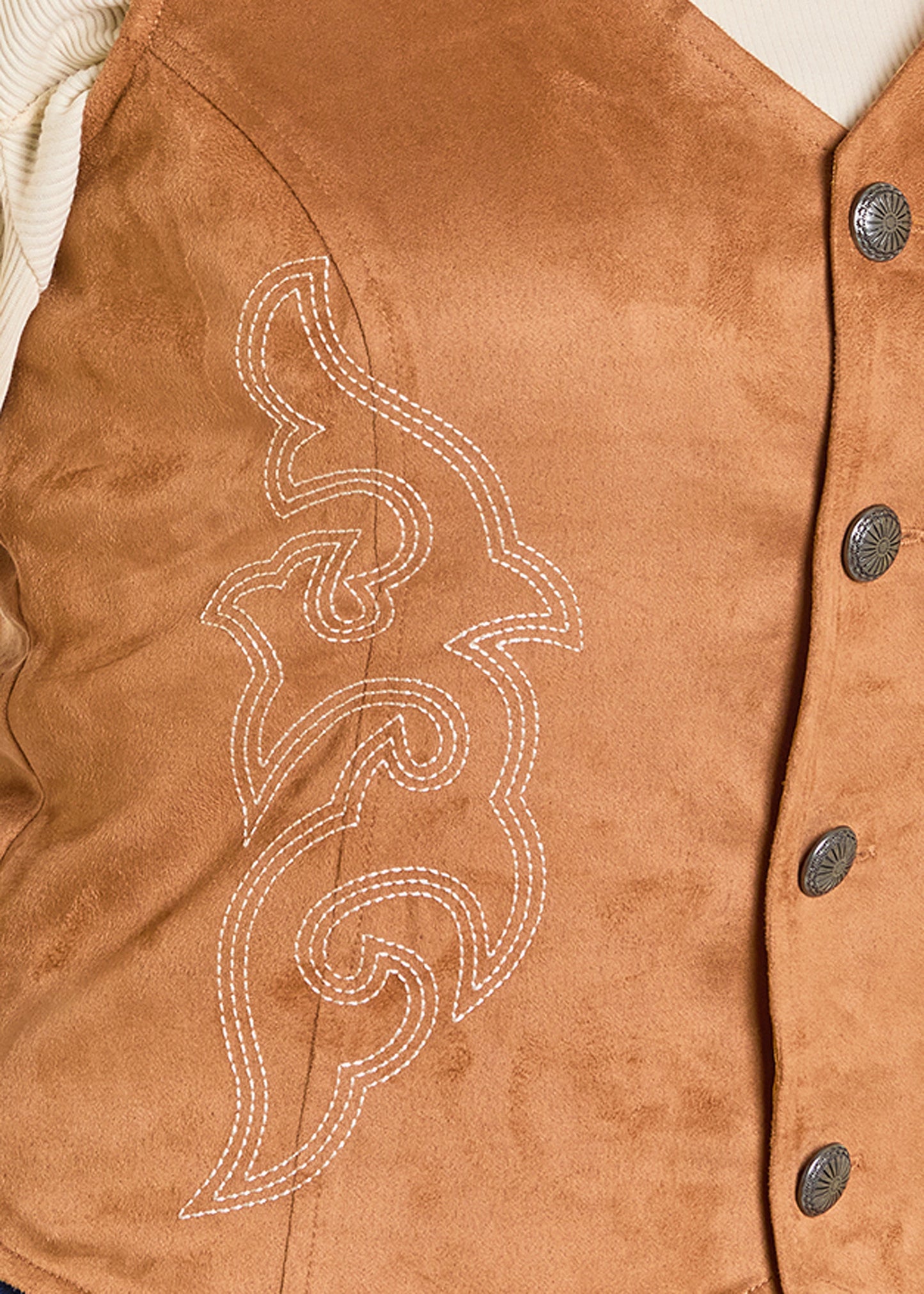 Close-up of a brown leather vest with decorative stitching and buttons.