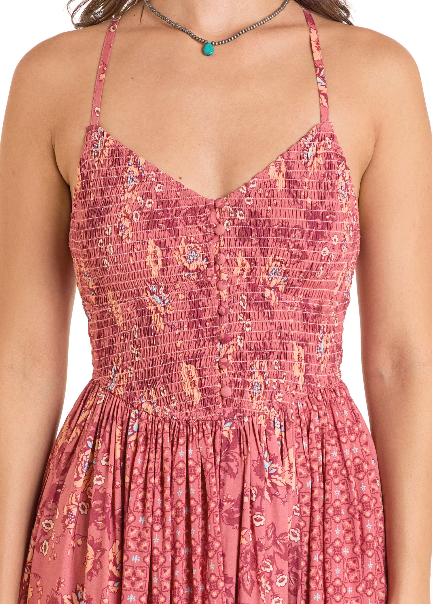 A woman wears the Rock & Roll Denim Mixed Print Maxi Dress, featuring a sleeveless design with thin straps, a smocked top, and flowy floral skirt, paired with a turquoise necklace.