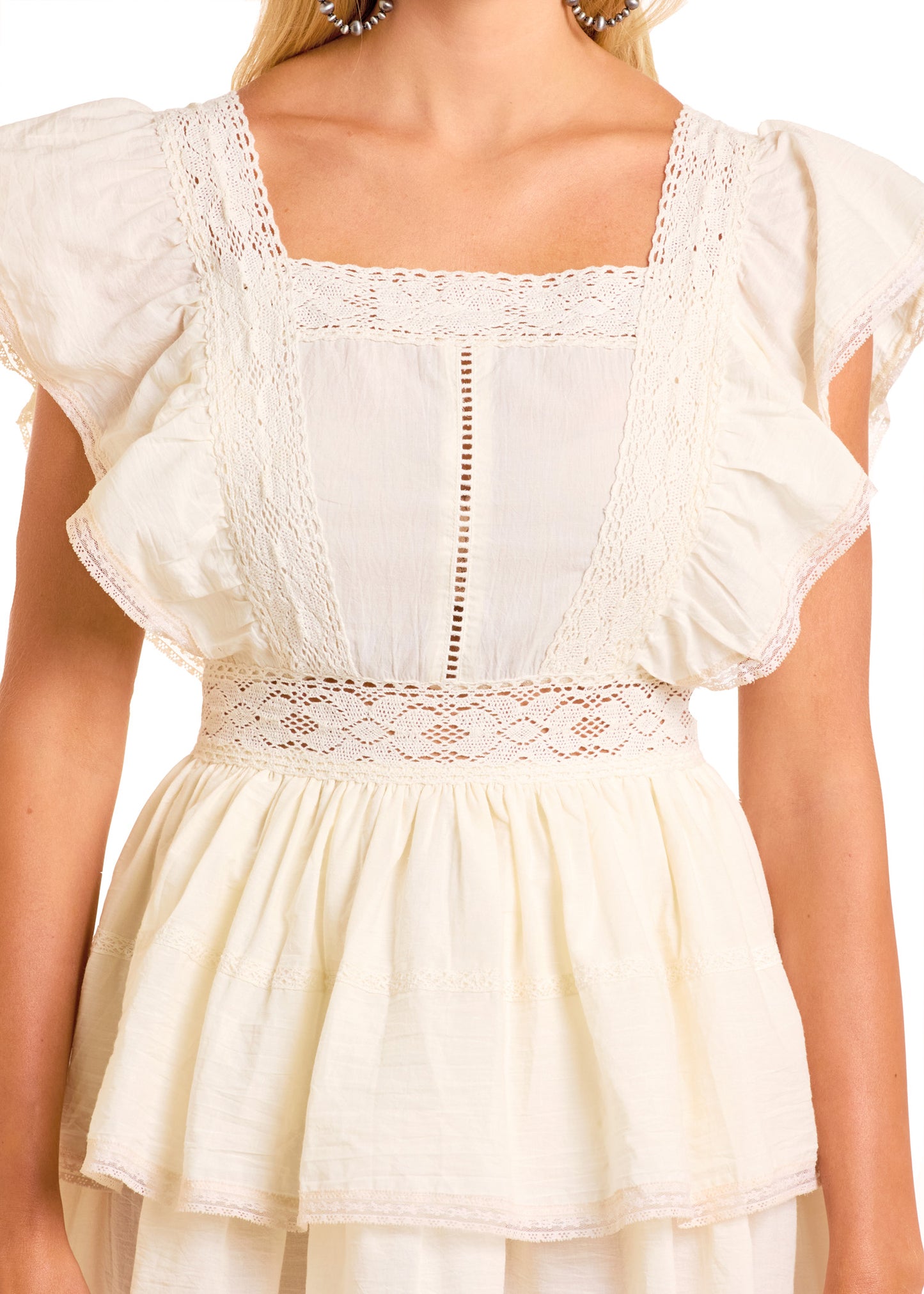 A woman models the Rock & Roll Denim Flutter Sleeve Mini Dress in off-white, featuring ruffled details, lace trim, a square neckline, and a fitted waist. Only her upper half is visible.