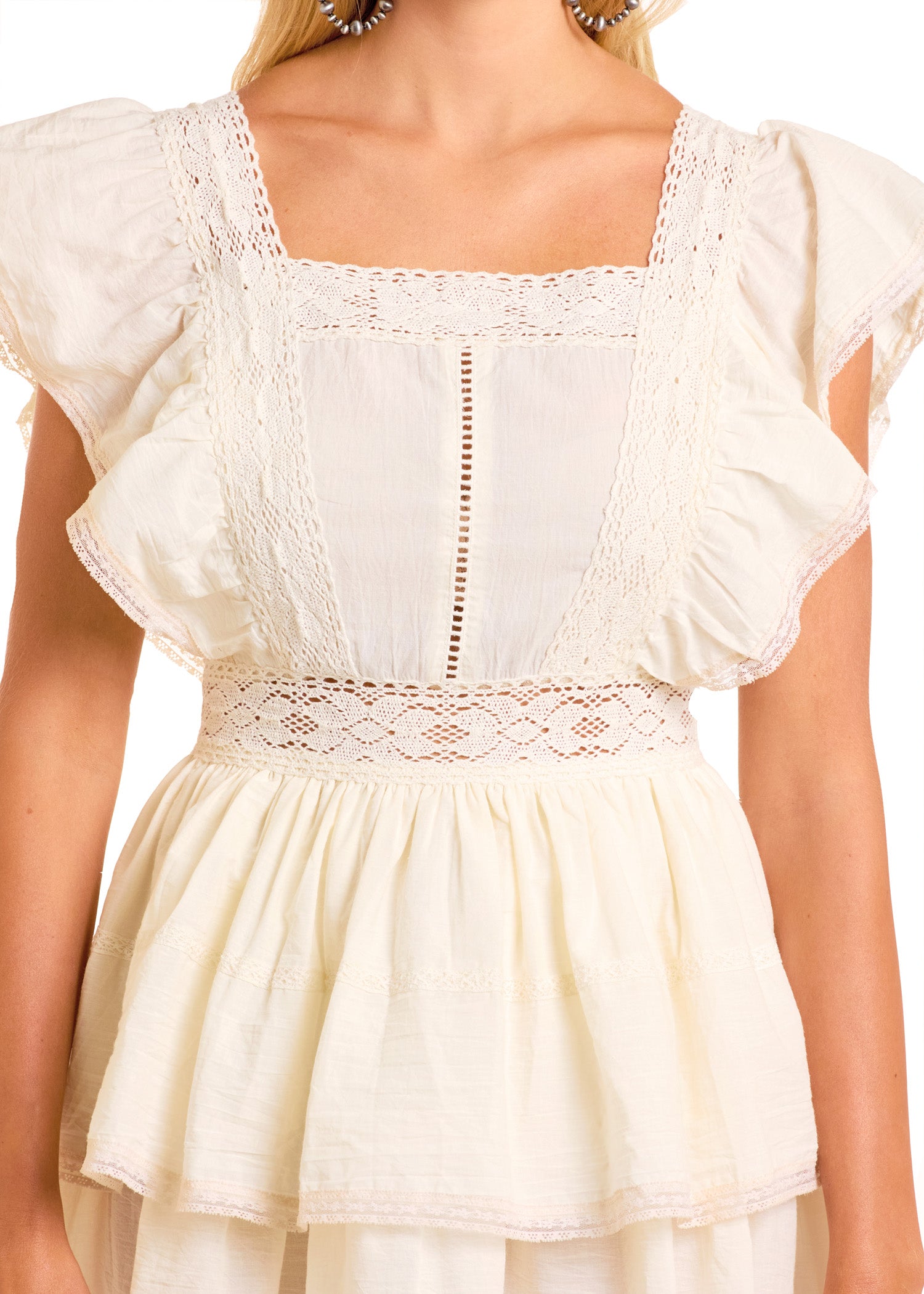 A woman models the Rock & Roll Denim Flutter Sleeve Mini Dress in off-white, featuring ruffled details, lace trim, a square neckline, and a fitted waist. Only her upper half is visible.