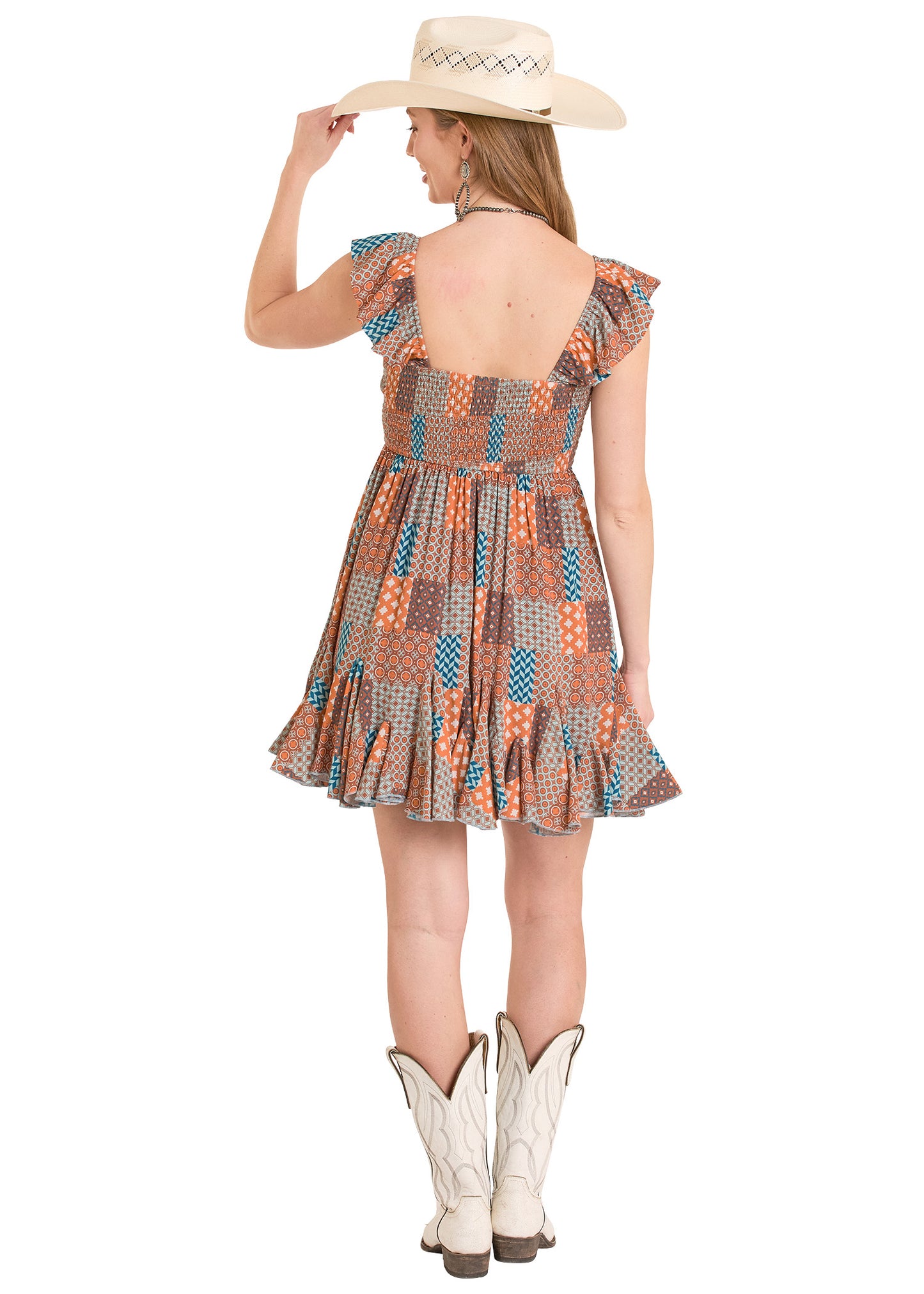 Woman wearing a patterned dress, white cowboy boots, and a straw hat on a white background