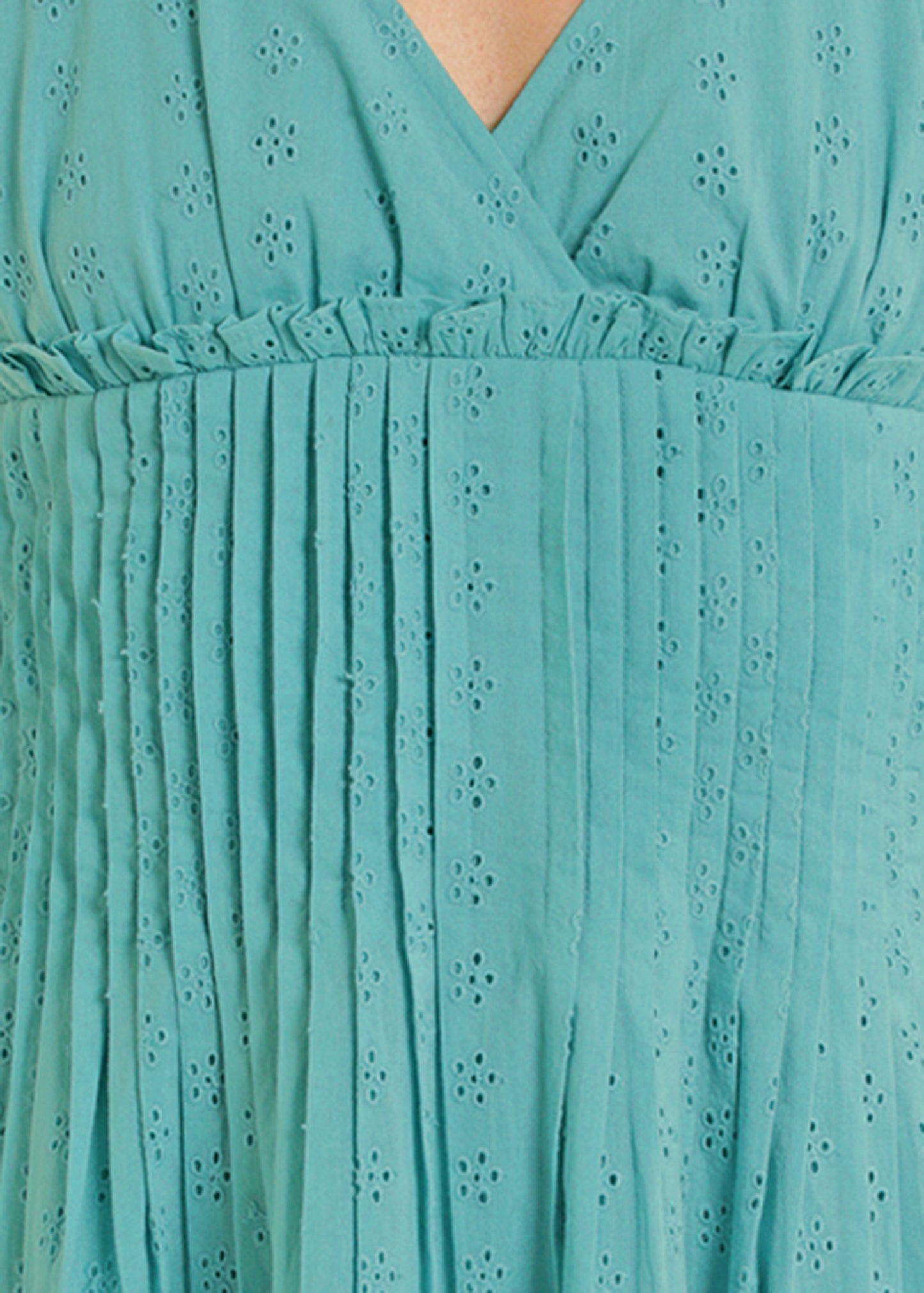 Close-up of a turquoise dress with eyelet detailing