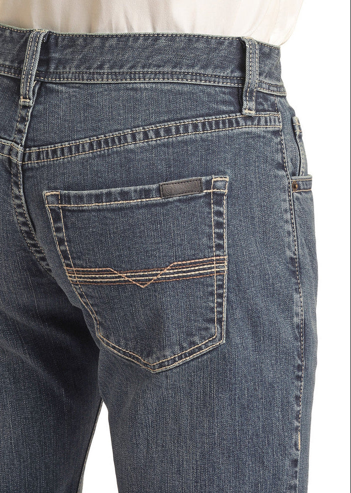 A close-up shows the back of a person wearing Rock & Roll Denim’s Vintage '46 Regular Fit Stackable Bootcut Jeans with a tucked-in white shirt, highlighting the back pockets and waistband.