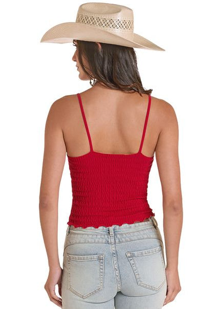 Woman wearing a red tank top and light blue jeans with a straw hat on a white background