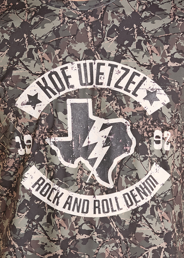Detail image of a camouflage graphic t-shirt with a white 'Kode Wetzel Rock and Roll Devil' logo on the chest