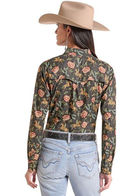 A woman shown from the back wearing a long-sleeve western-style button-up shirt with a dark green floral print, light-wash blue jeans, a black belt, and a beige cowboy hat, against a plain white background.