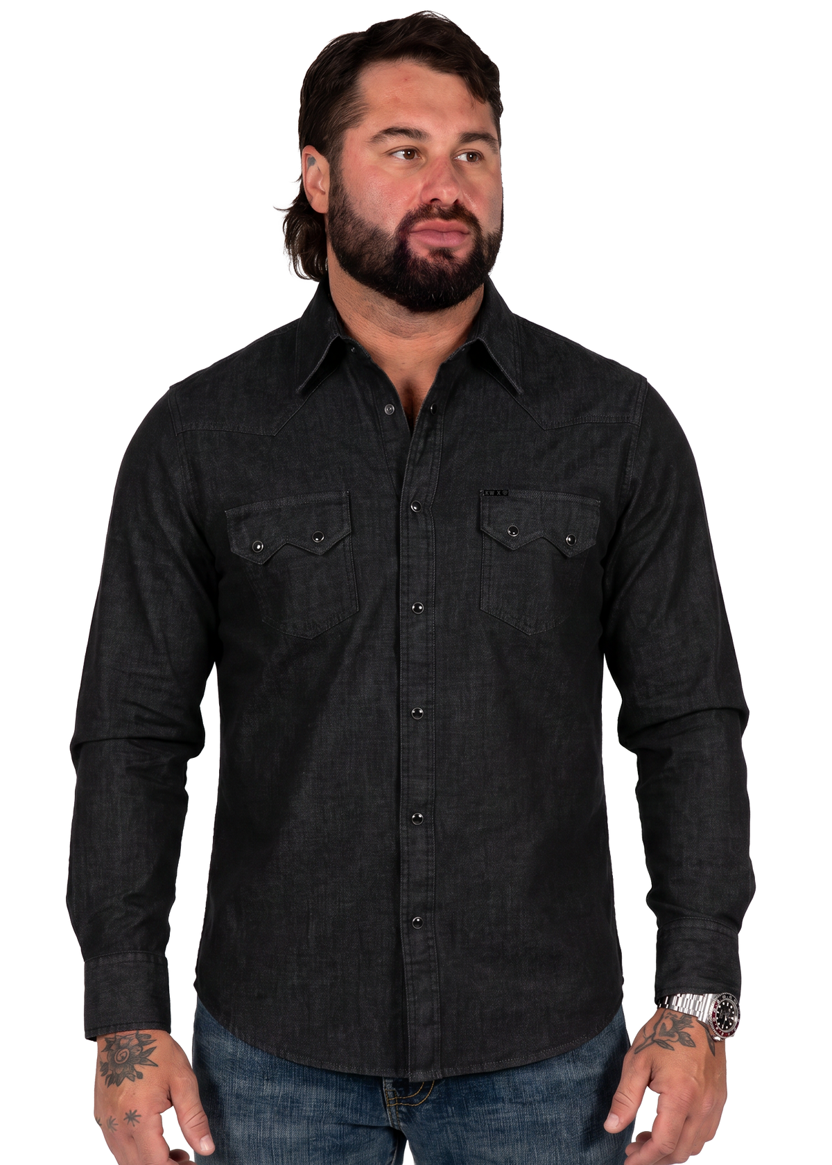 Koe Wetzel wearing a dark charcoal gray long-sleeve western-style button-down shirt with two chest pockets, paired with blue jeans, against a plain white background.