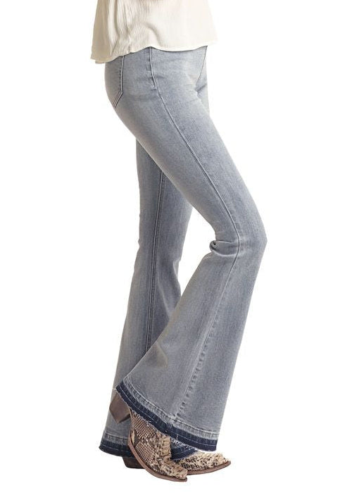 Woman wearing a cowboy hat, white top, and blue jeans on a white background