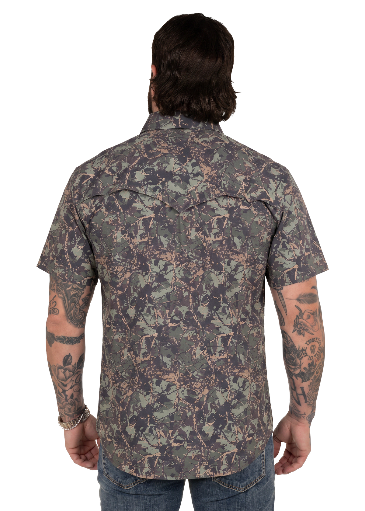 Koe Wetzel viewed from the back wearing a short-sleeve button-up shirt with an allover woodland camouflage pattern in green, brown, and gray tones, paired with blue jeans against a plain white background.
