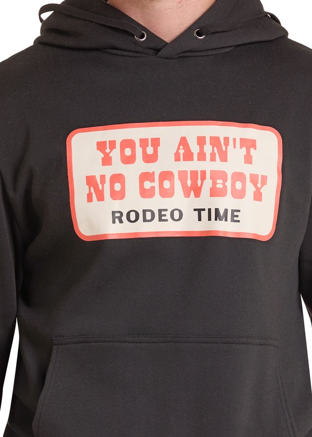 A close-up of a black hoodie featuring a graphic print on the chest that reads 'YOU AIN'T NO COWBOY RODEO TIME' in red and black text.