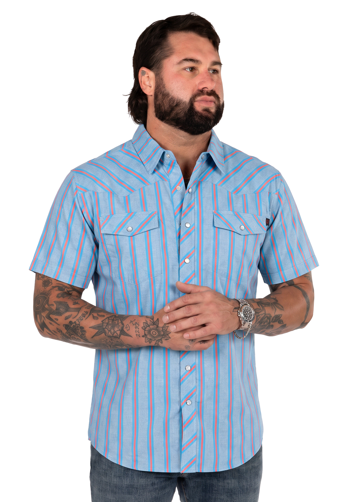 Koe Wetzel wearing a short-sleeve button-up shirt with vertical light blue, pink, and white stripes, paired with dark jeans, photographed against a solid white background.
