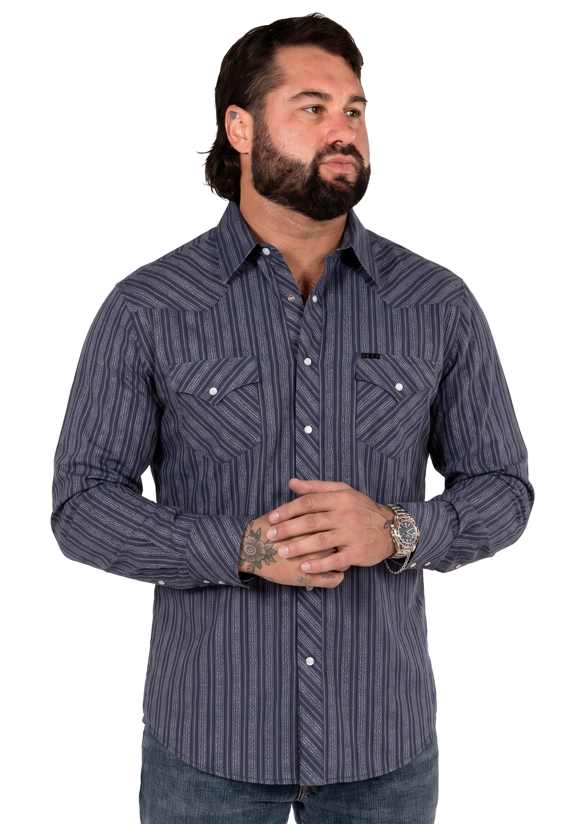 Koe Wetzel wearing a long-sleeve western-style button-down shirt with vertical navy and gray stripes, paired with dark jeans, photographed against a solid white background.