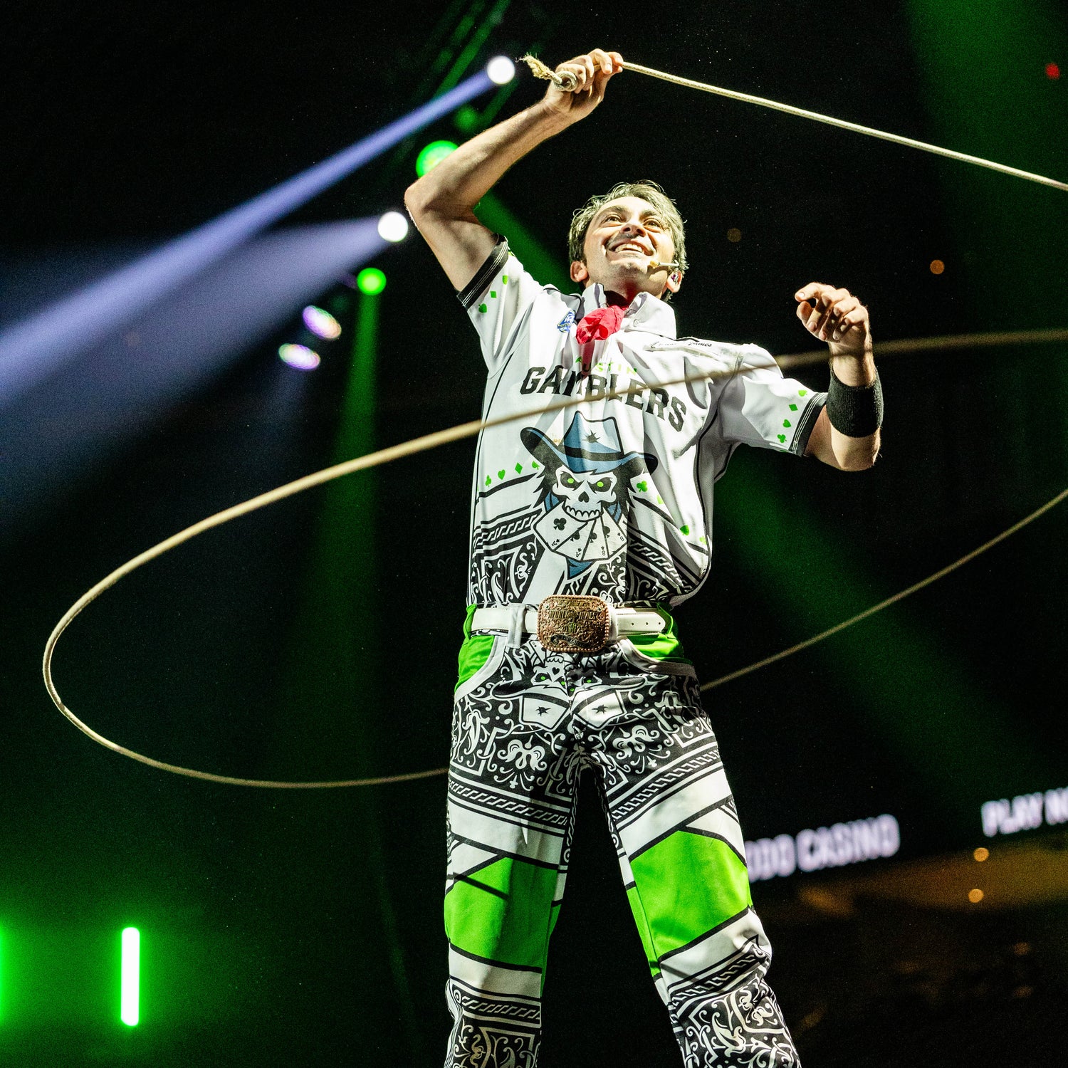 Person performing with a hoop on a stage with green lights