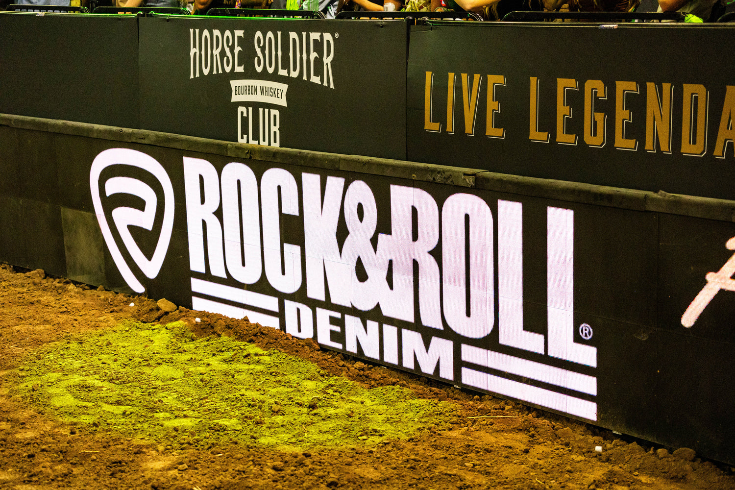 Promotional banner with 'Rock & Roll Denim' branding on a grassy area.