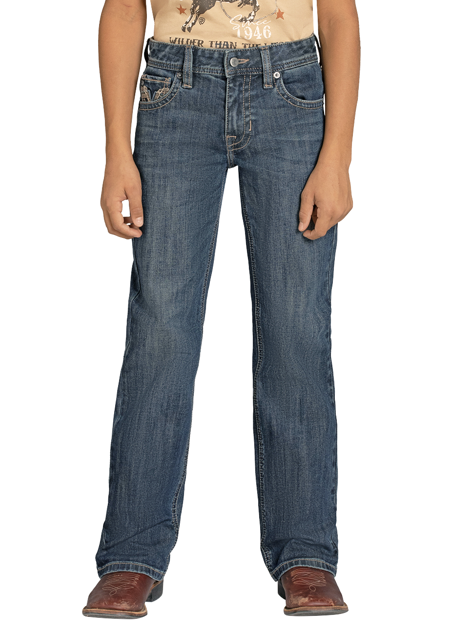 A person stands facing forward against a plain background, hands relaxed at their sides, wearing a beige graphic t-shirt, Boys' Regular Fit Feather Stitch V Bootcut Jeans by Rock & Roll Denim in blue, and brown leather boots.