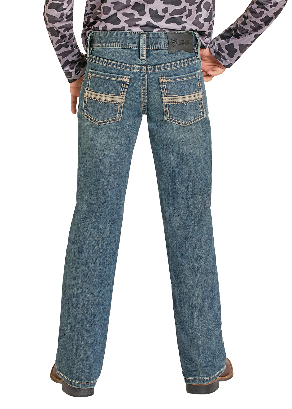 A person is seen from behind wearing Rock & Roll Denim Boys' Regular Fit Pleather Stitch Bootcut Jeans, brown shoes, and a patterned long-sleeve shirt.