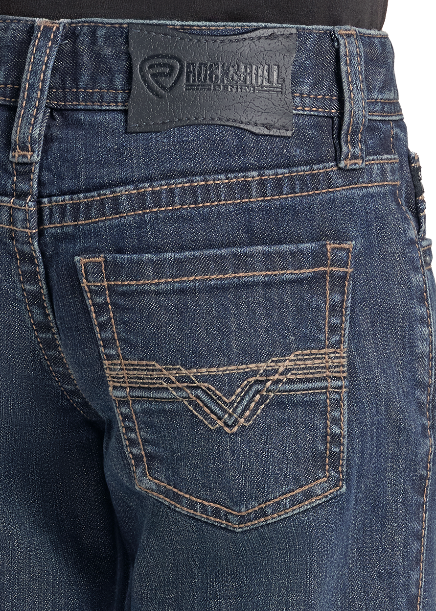 Close-up of the back pocket of dark blue denim jeans with contrast tan stitching and a black Rockshell brand patch on the waistband.