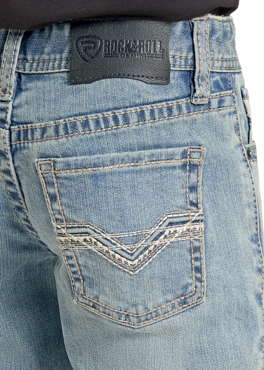 Close-up of the back waistband and pocket area of light-wash blue denim jeans, showing a black Rockroll brand patch and decorative contrast stitching.