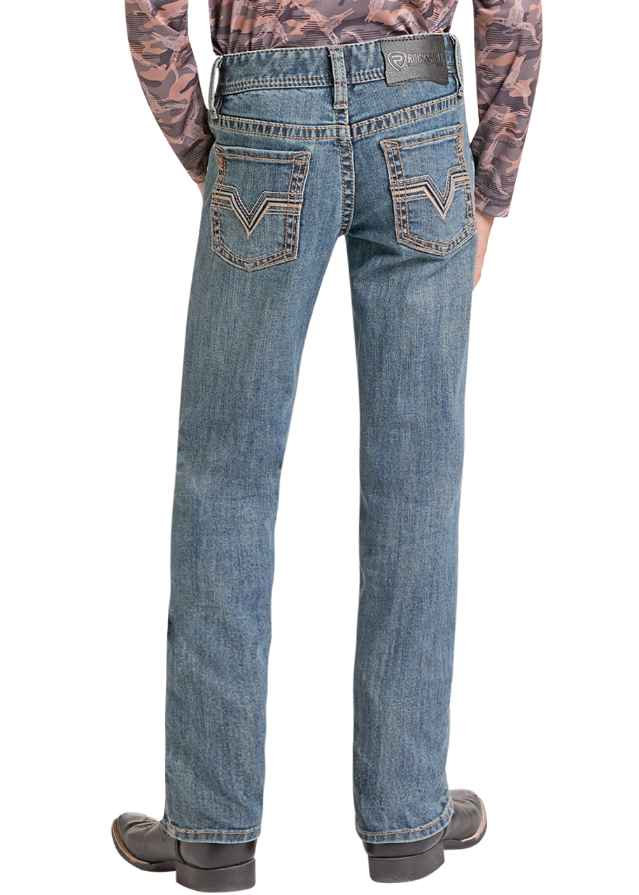 A child shown from the back wearing a long-sleeve camouflage-patterned hoodie, blue jeans, a black cowboy hat, and boots against a plain white background.